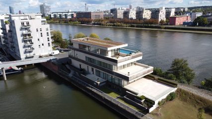 Moderne Architektur am Wasser mit Terrasse und Swimmingpool.